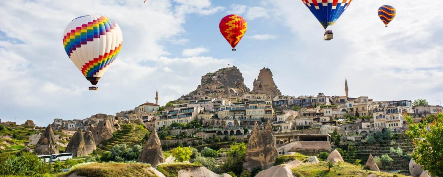 Paisaje de Uçhisar en Capadocia con globos aerostáticos