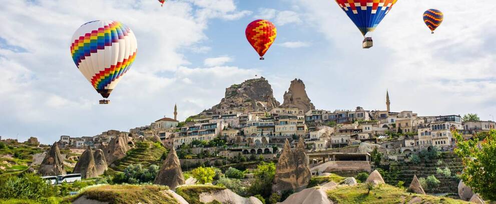 Paisaje de Uçhisar en Capadocia con globos aerostáticos